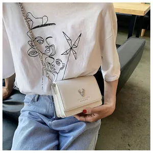 Détail du sac bandoulière en cuir blanc cassé avec boucle en métal tête de cerf argent
