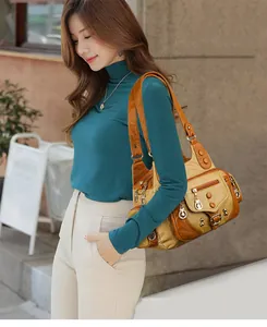 Detailed side view of multi-pocket vintage shoulder bag with rivets on soft faux leather