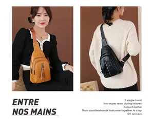 Dettaglio dei borselli monospalla in pelle lavata con tasche zip e nappe decorative