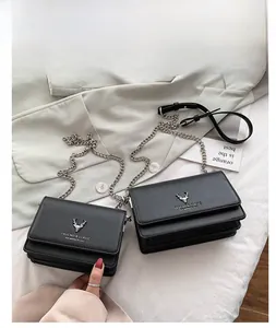 Détail du sac bandoulière en cuir noir avec logo cerf argenté et bandoulière en chaîne