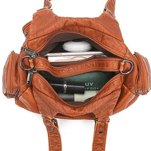 Caramel soft leather crossbody bag with multiple zippers and spacious interior capacity