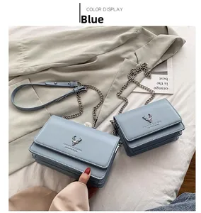Détail du sac à bandoulière en cuir PU bleu avec logo de tête de cerf doré