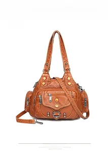 Front view of vintage brown washed leather bag with multi-pocket design and silver rivets