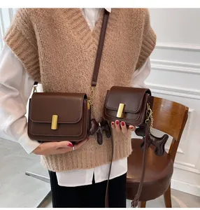 Sacs bandoulière en cuir marron élégants portés par un mannequin en tenue