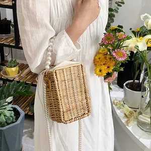 Fashionable woven straw crossbody bag with large pearl handle and drawstring lining