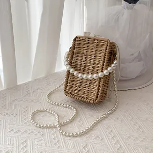 Handcrafted straw woven crossbody bag with pearl chain handle and drawstring lining