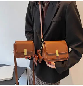 Comparaison entre petits et moyens sacs à bandoulière en cuir marron avec un charme de cheval