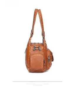Detailed side view of brown vintage leather handbag with multi-zipper pockets and handles