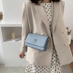 Petit sac à bandoulière bleu clair en similicuir avec chaîne et logo cerf