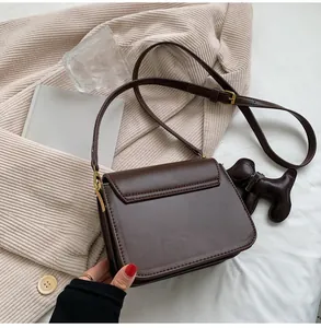 Vue arrière d'un petit sac à bandoulière carré marron classique avec une lanière