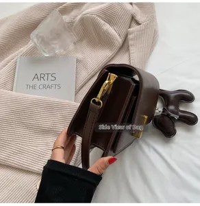 Détail de la vue latérale d'un sac à bandoulière carré en cuir marron classique