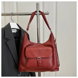 Detail view of large dark red tote bag featuring a front pocket with silver buckle closure