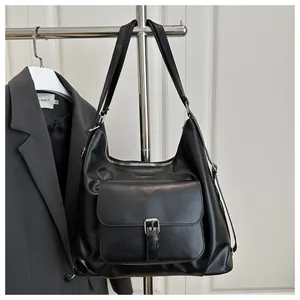 Detail of black matte PU leather tote bag with metallic buckle pocket and zipper closure