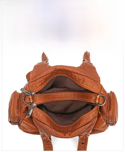 Macro view of the internal multi-layer zippered compartments in a brown vintage handbag