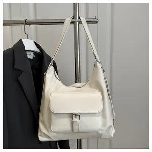 Detail view of cream-colored hobo tote bag with small outer pocket and soft leather texture