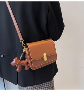 Vue arrière d'un sac à bandoulière carré chic en cuir marron avec détails dorés élégants