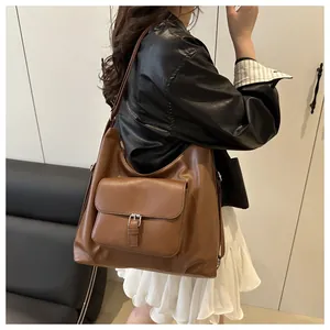 Detail of dark brown vintage faux leather tote bag with front metal buckle pocket