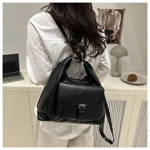 Detail of a black large-capacity leather tote bag featuring a front buckle flap pocket