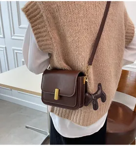 Petit sac bandolera vintage en cuir marron avec breloque chien mignonne et fermoir doré