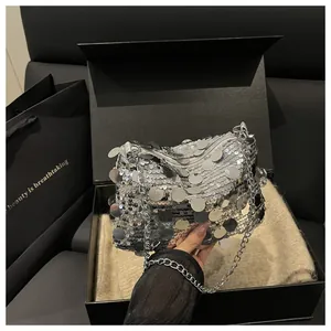 Detailed view of silver sequin square bag with elegant metal chain in a black gift box