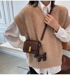 Vue détaillée d'un élégant sac à bandoulière marron minimaliste avec un charmant pendentif chien