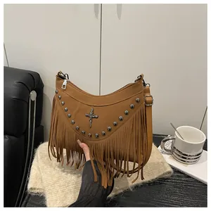 Detailed macro view of brown suede handbag featuring silver studs and long fringe tassels
