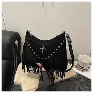 Close-up of black crescent moon bag with silver rivets, gothic cross, and long fringe detail