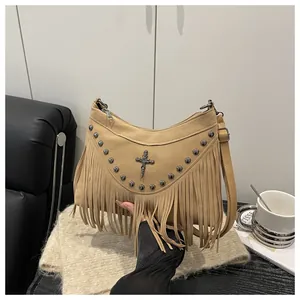 Detailed view of retro tassel shoulder bag with silver rivets and cross metal emblem