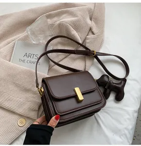 Sac bandoulière marron minimaliste avec fermoir doré et petit charm chien élégant