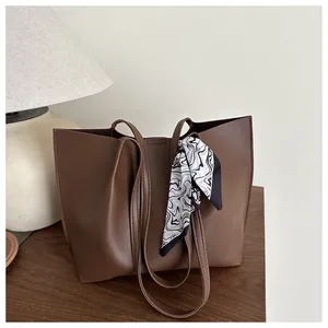 Detail of large brown tote bag with decorative black and white patterned silk scarf