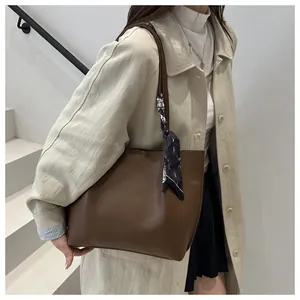 Brown faux leather tote bag with geometric silk scarf detail on handle for stylish commuting