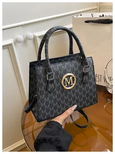 Dettaglio borsa a mano nera monogram con logo M dorato e tracolla regolabile