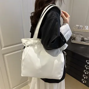 Minimalist white drawstring tote bag with Fashion label shown on shoulder of model