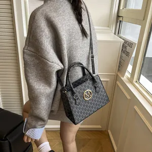 Elegante borsa a mano monogramma nera con logo dorato e tracolla regolabile versatile