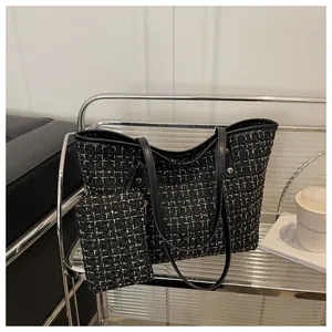 Détail du sac cabas en tweed avec lanières en cuir noir, rivets dorés et pochette interne