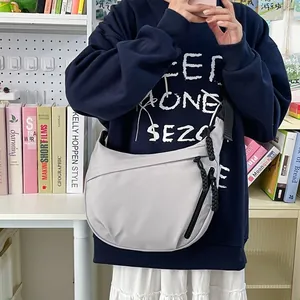 Sac fourre-tout demi-lune gris clair minimaliste avec bandoulière large et poche zippée