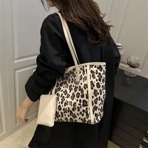 Large leopard print tote bag with cream straps and matching pouch shown on shoulder