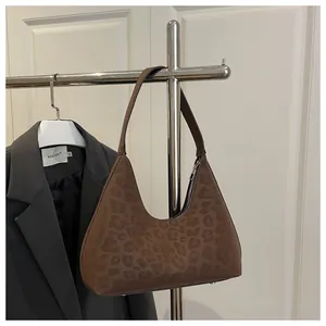 Details der Leopard-Halbmondtasche mit Wildlederstruktur und Metall-Schutzfüßen
