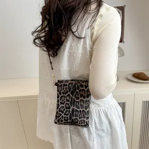 Vintage leopard print square bag with chain strap shown on a white blouse outfit