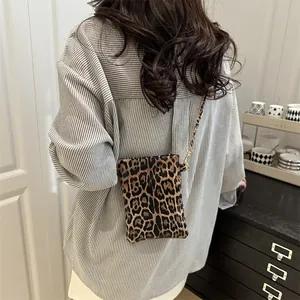 Retro leopard print crossbody bag with chain strap shown on model in cozy interior
