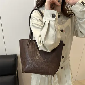 Large dark brown crocodile embossed tote bag for women showing a stylish commute look