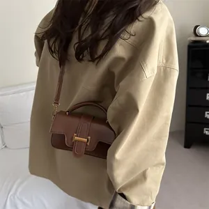 Brown leather square bag for women worn as a crossbody bag with a minimal autumn outfit