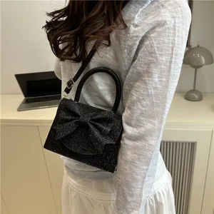 Elegant black sequin handbag with large bow decoration and pearl handle for women