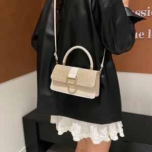 Elegante cremefarbene Lederhandtasche mit Pailletten-Überschlag und goldener Schließe