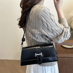 Classic black faux leather shoulder bag with silver buckle and knotted strap detail