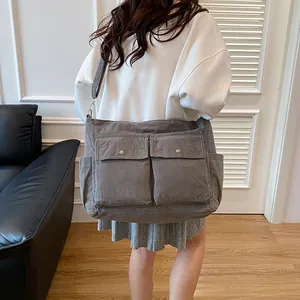 Große graue Cord-Einkaufstasche mit zwei Vordertaschen in lässiger Lifestyle-Umgebung