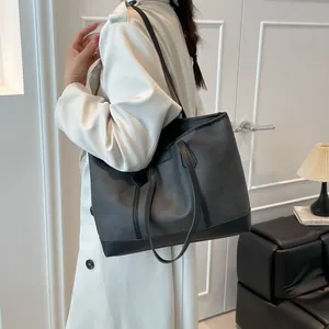 Grand sac cabas noir minimaliste avec texture mate et garniture en cuir brillant chic