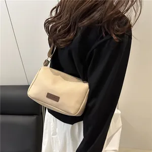 Minimalist beige water-resistant nylon crossbody bag with adjustable fabric shoulder strap