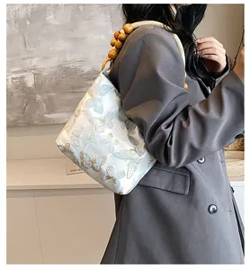 Detail der Jacquard-Achseltasche mit blauen Schmetterlingsmustern und Bambus-Holzperlen