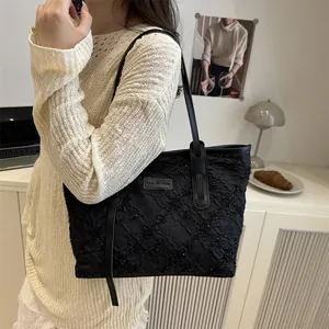 Grande borsa tote nera con paillettes e motivo a rombi indossata da modella